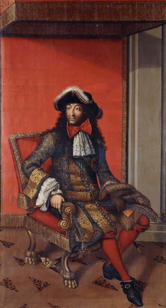 Portrait du roi Louis XIV assis en longueur dans un manteau bleu et or brode avec une fraise blanche et un chapeau borde de fourrure sur un trone
