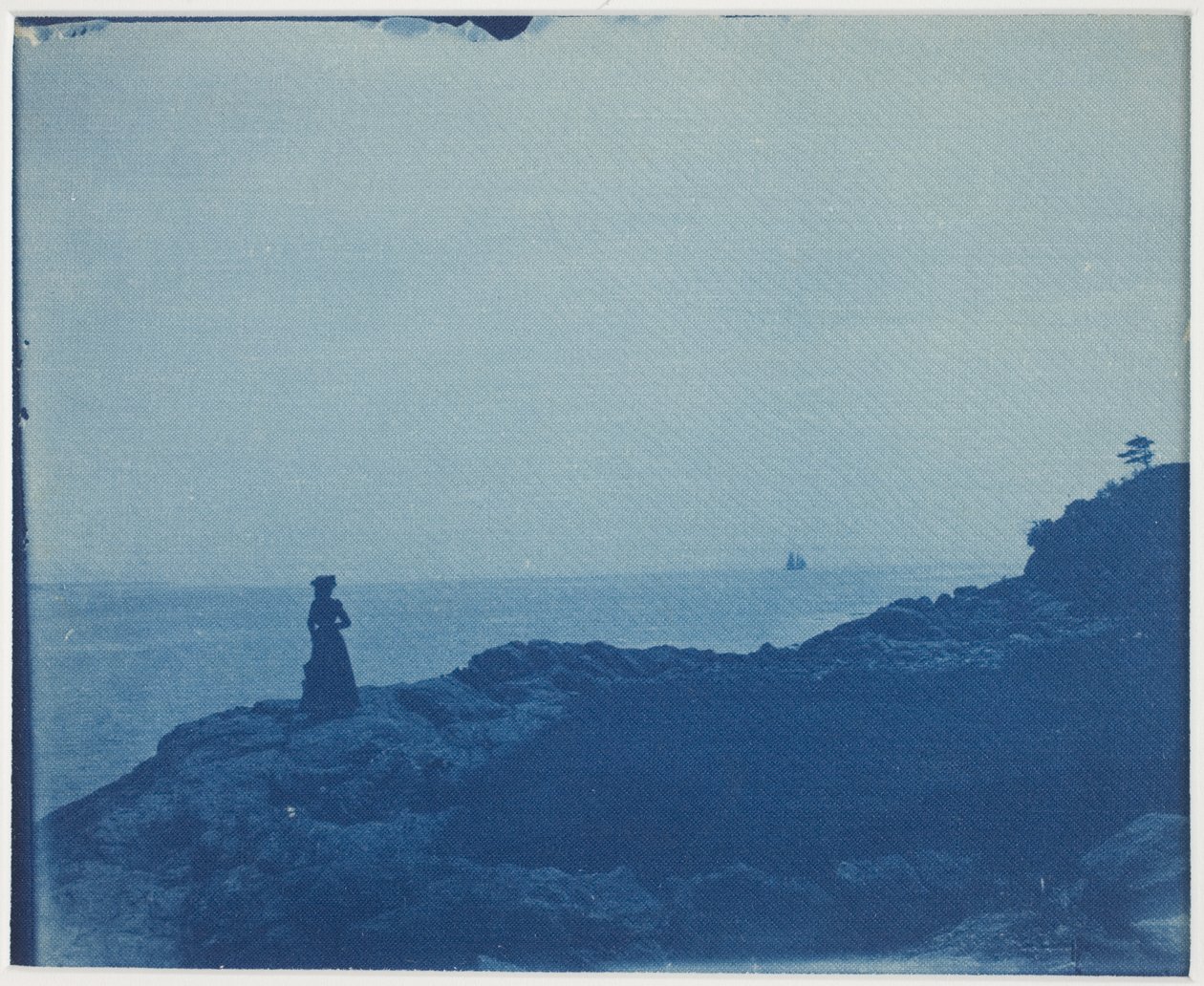 Femme regardant une goélette depuis un promontoire rocheux - American Photographer