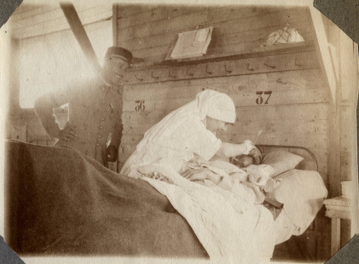 Première Guerre mondiale 1914-1918 : infirmière en blouse rasant un soldat (blessé de guerre français allongé dans un lit), à Couville, Manche, Basse-Normandie, France. Photographie anonyme juillet 1917. Collection privée, Stella. - Anonymous Anonymous