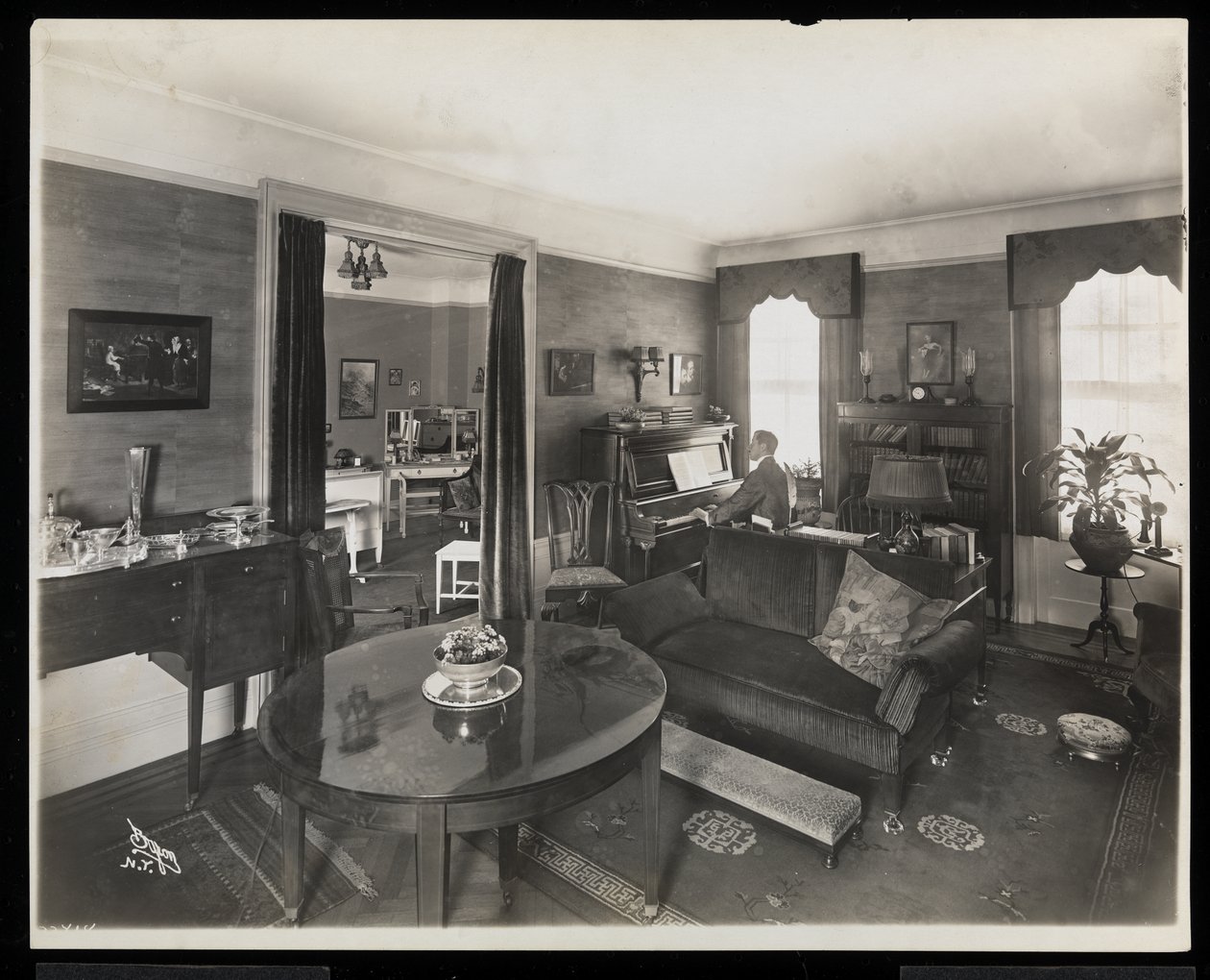 Un homme jouant du piano dans un salon de la résidence A.C. Cronin, 1915-16 - Byron Company