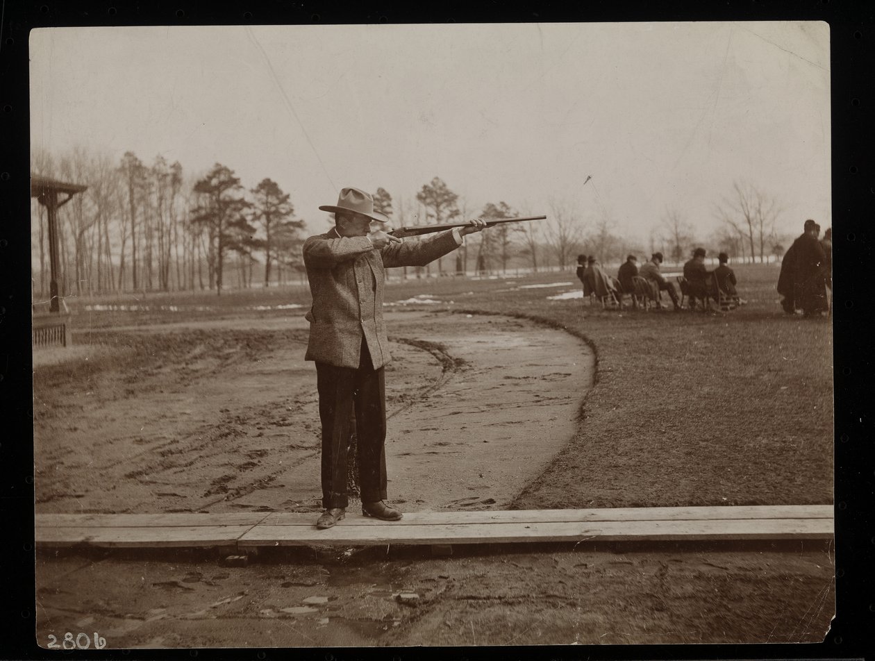 Frank Work visant un fusil à un tir au piège, New York, 1896 - Byron Company