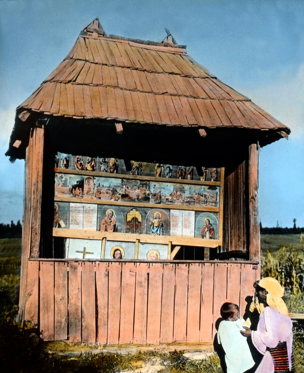 Roumanie, Bucovine, mère avec enfant devant une petite chapelle avec des images des Saints, date de l