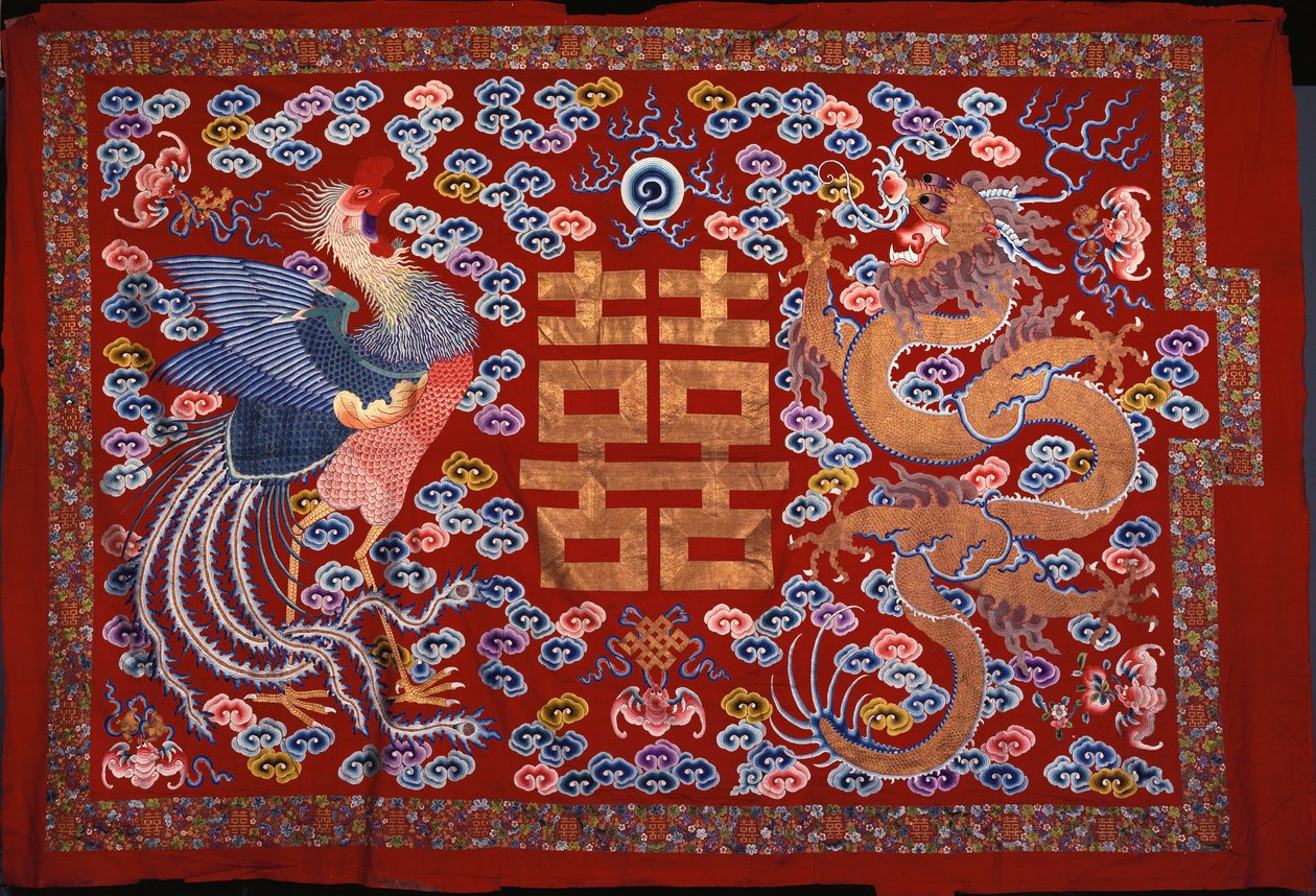Un pendentif chinois en laine rouge avec un caractère central en fil doré flanqué d
