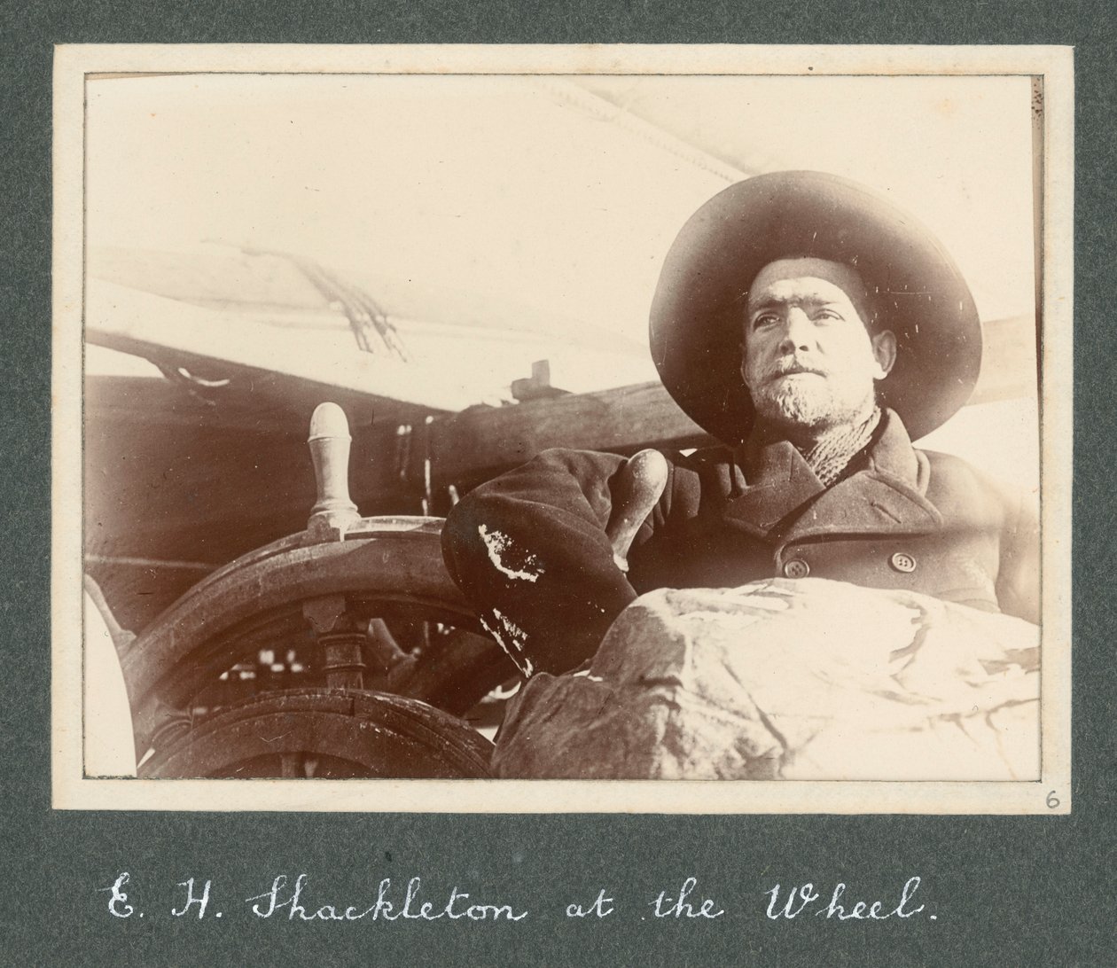 E H Shackleton debout près de la roue du 