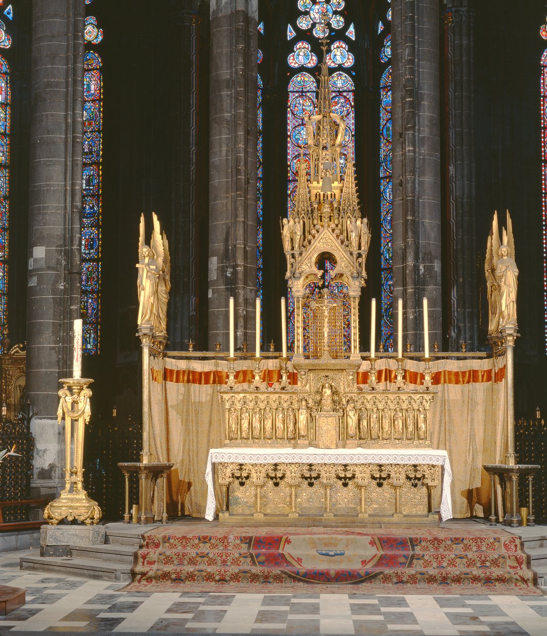 Haut autel de style néo-gothique, entouré de 4 anges portant les instruments de la Passion du Christ avec un tabernacle surmonté d
