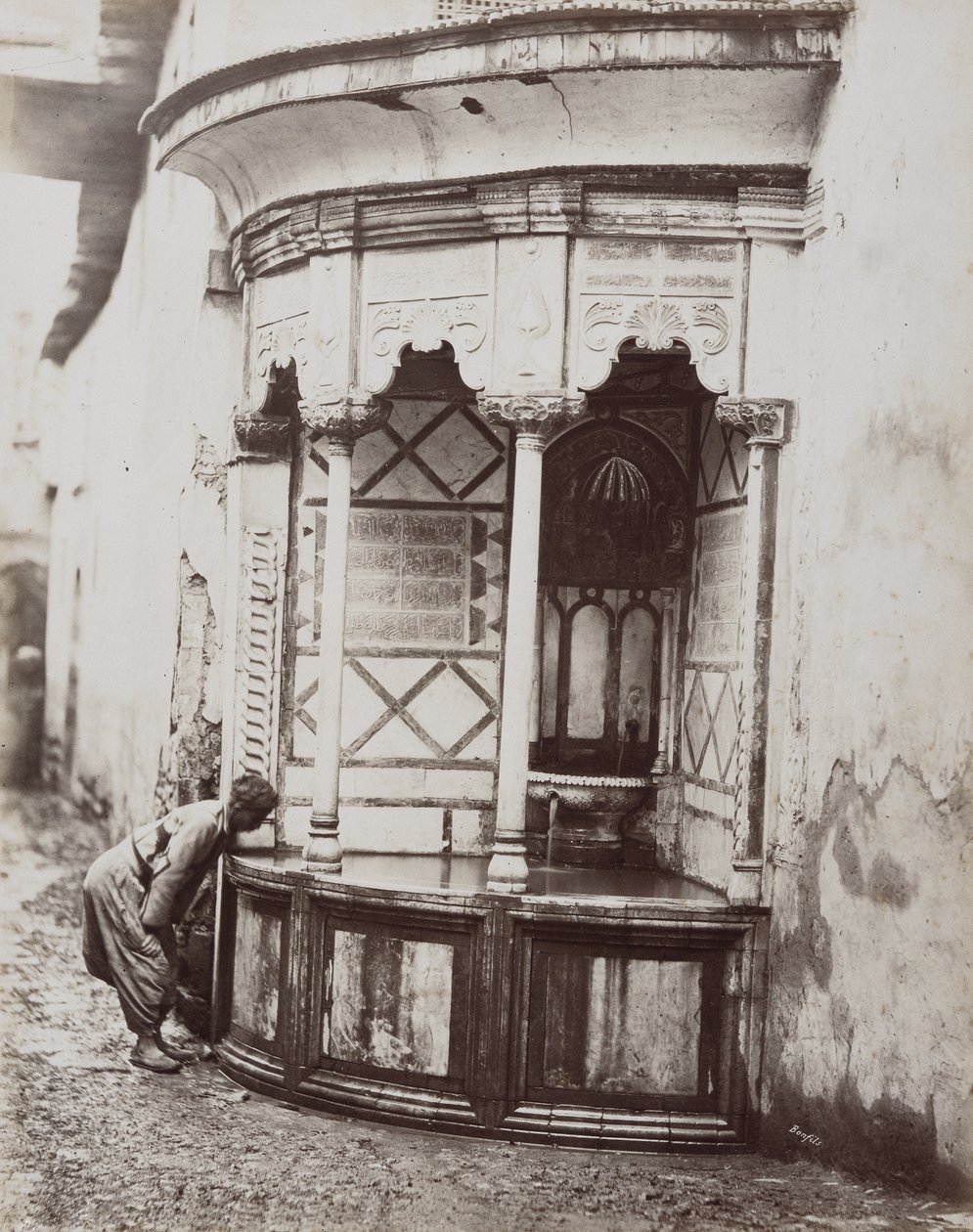 Un homme buvant à une fontaine d