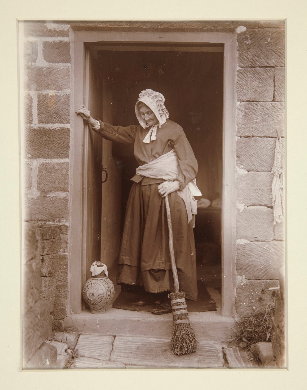Une vieille dame avec une bouteille de levure à la porte d