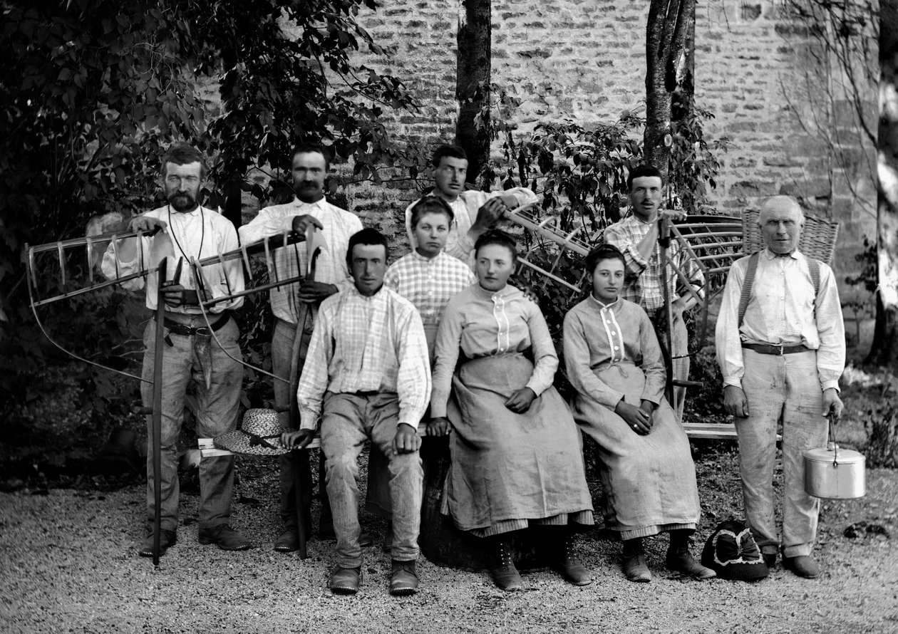 Travailleurs agricoles et leurs outils, faux, râteau-étrier, panier de tressage et récipient pour la collecte, dans une ferme près de Bourmont en Haute-Marne, vers 1890. Photographie. Collection Ducos - French Photographer