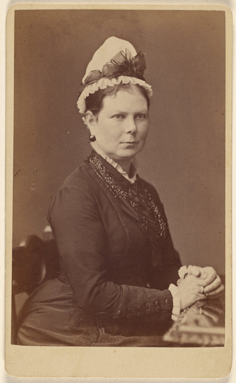 Femme non identifiée portant un bonnet à nœud, assise les mains jointes - George Washington Wilson
