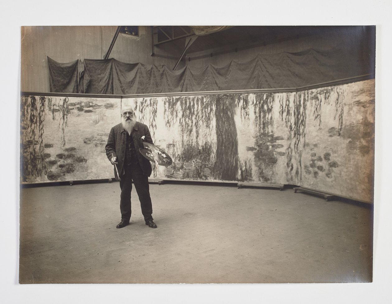 Claude Monet avec sa palette devant son œuvre 