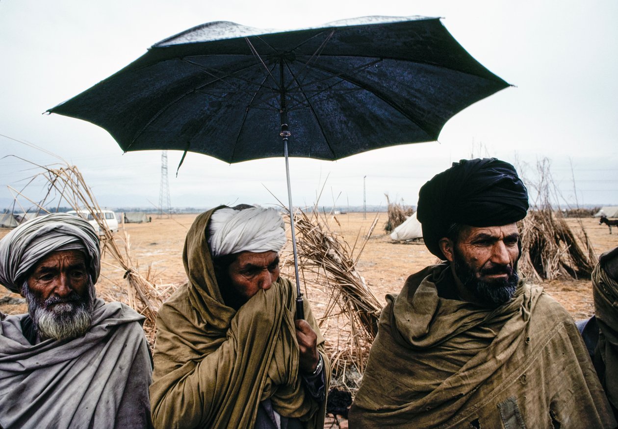 Hommes pakistanais avec un parapluie et des vêtements traditionnels - James L Stanfield