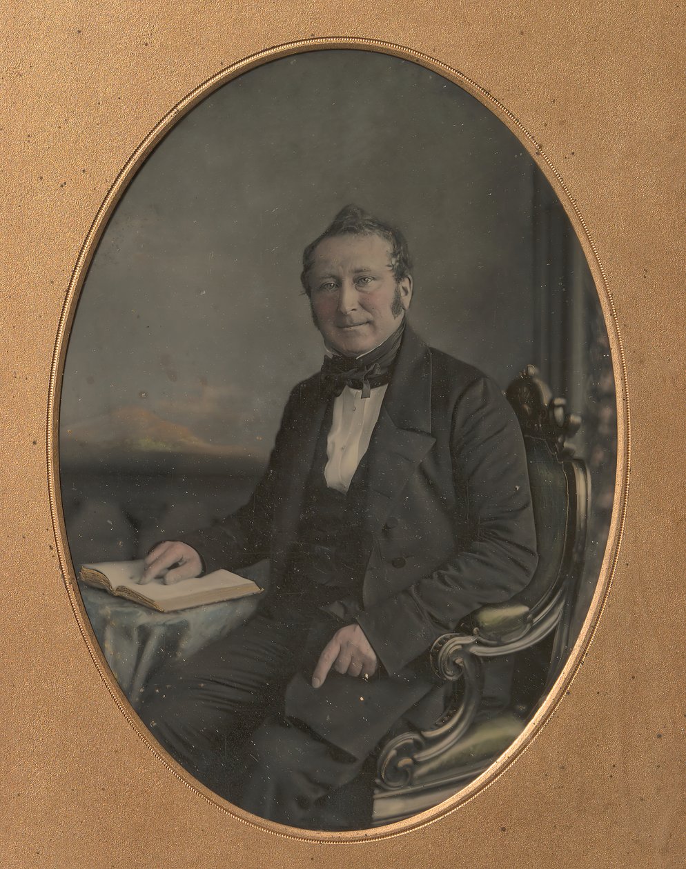 Homme assis pointant un passage dans un livre ouvert - John Jabez Edwin Mayall