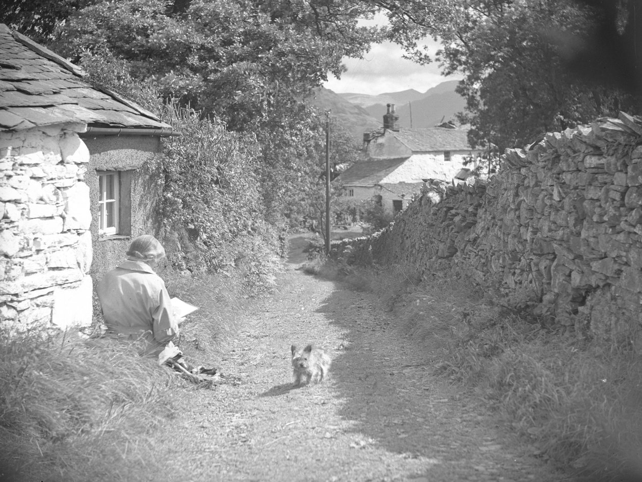 Une femme assise en train de lire avec un chien dans une ruelle - Joseph Hardman