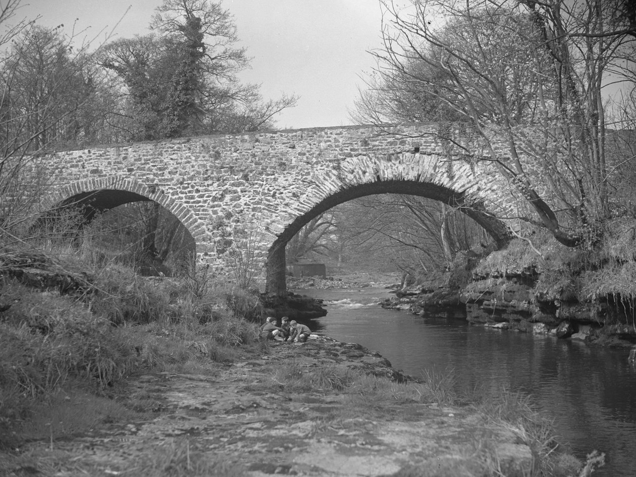Groupe de garçons accroupis au bord de la rivière sous un pont de pierre - Joseph Hardman