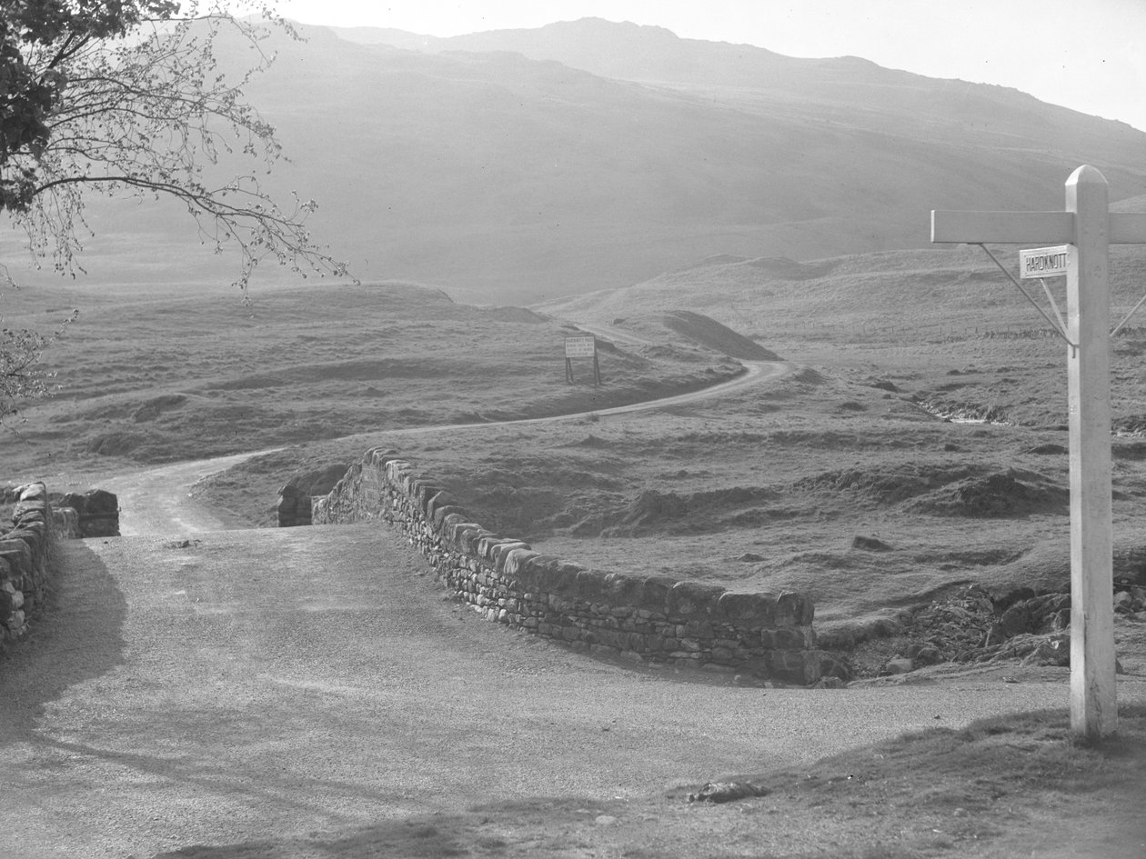 Vue de la route passant au-dessus du col de Hardknott avec un panneau indiquant la direction de Hardknott - Joseph Hardman