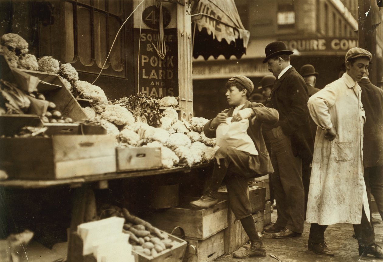 Un garçon travaillant à un stand de fruits et légumes à Boston, Massachusetts. - Lewis Wickes Hine