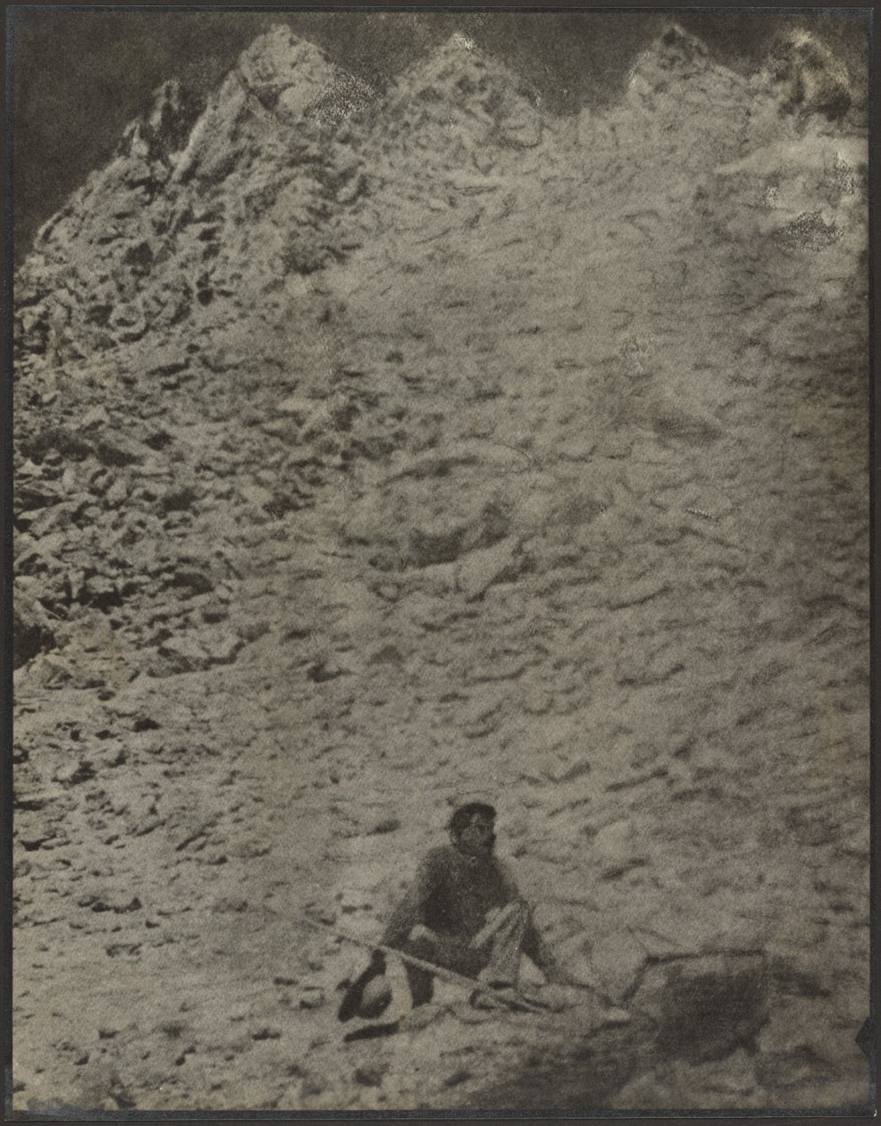 [Un homme accroupi dans un paysage rocheux] - Louis Fleckenstein