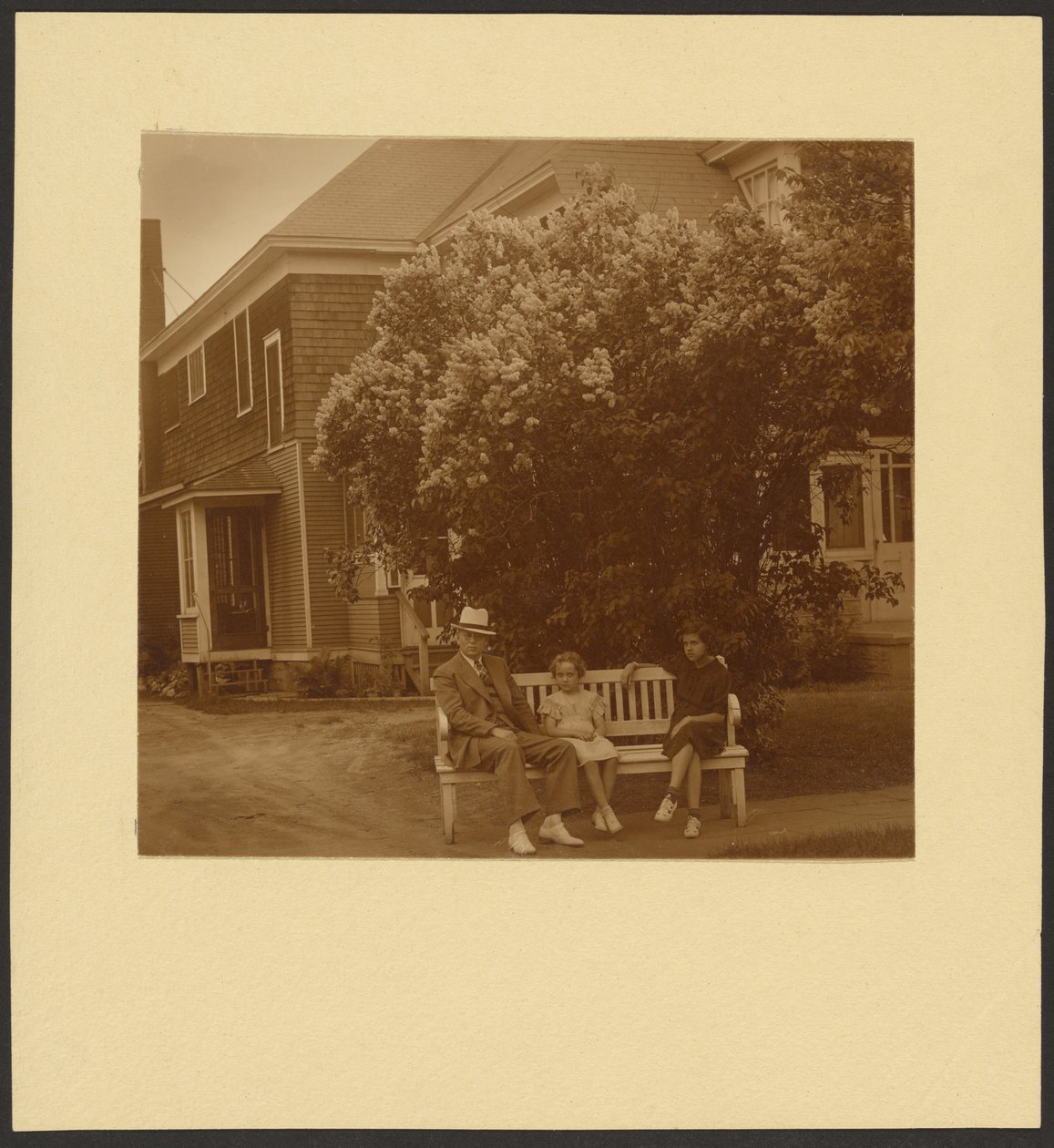 [Homme et jeunes filles sur un banc devant une maison] - Louis Fleckenstein