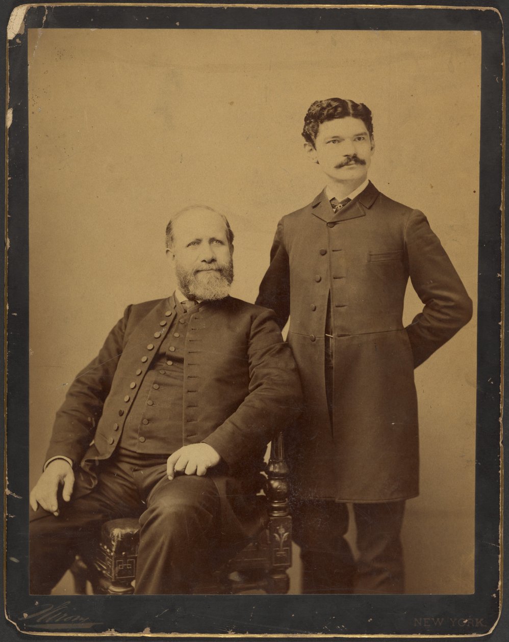 [Un homme barbu non identifié, assis, aux côtés d