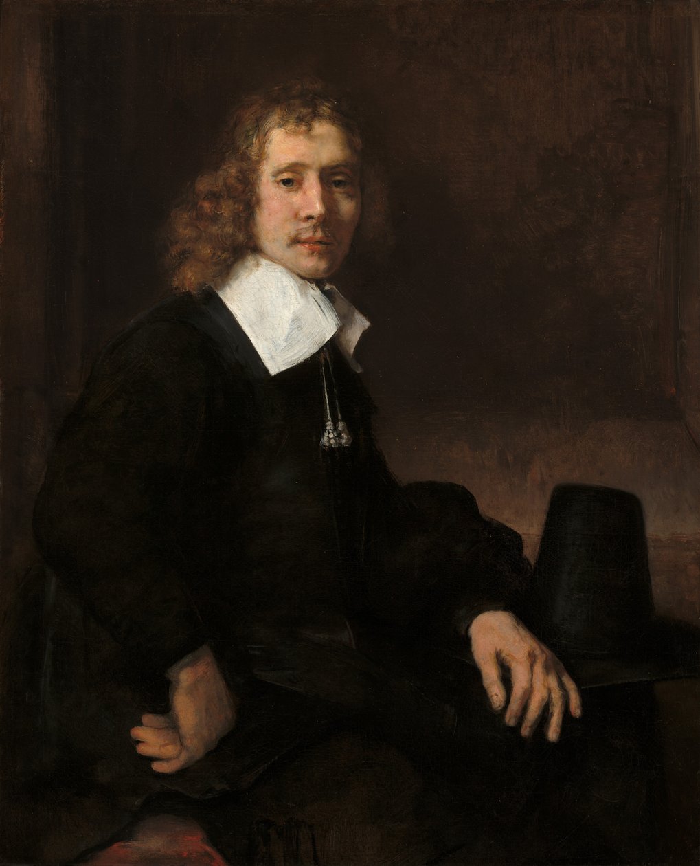 Un jeune homme assis à une table (peut-être Govaert Flinck) - Rembrandt van Rijn