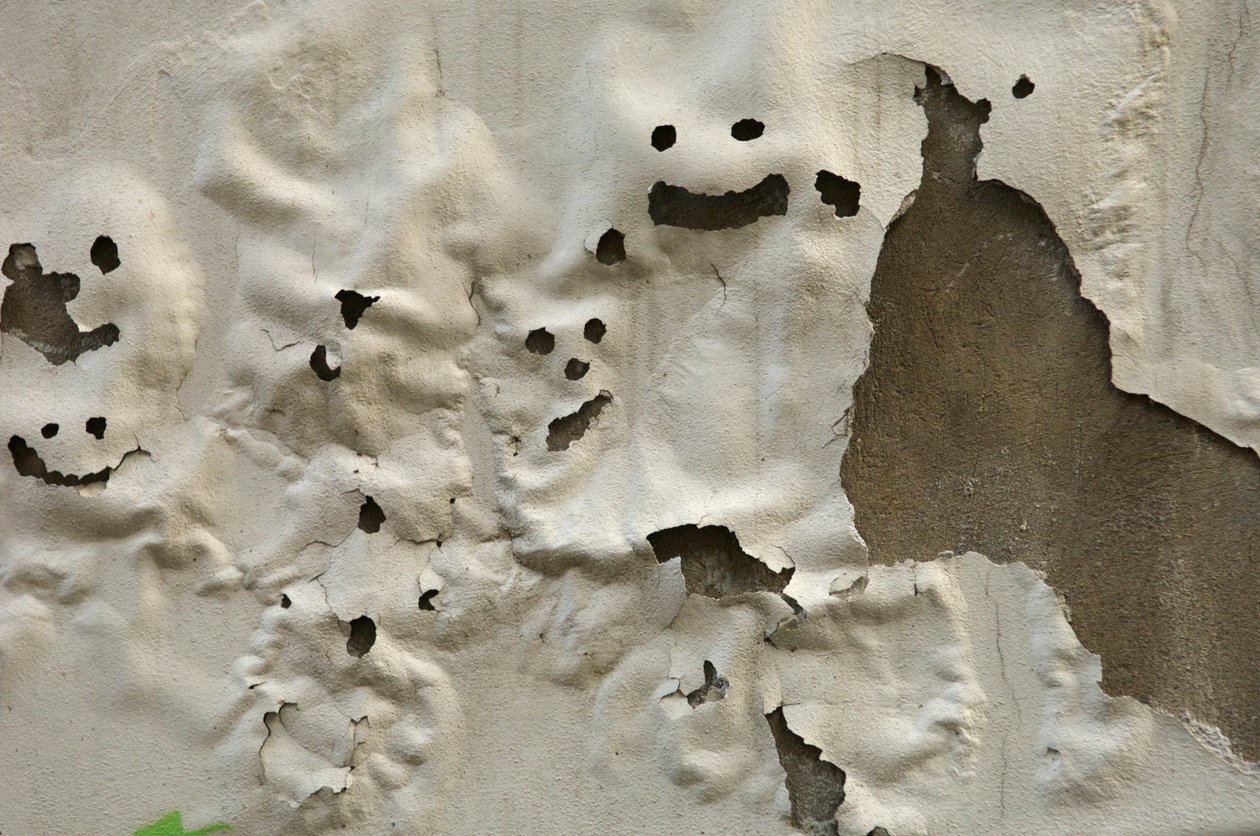 Italie, Toscane, Florence, visages de fantômes souriants sur un mur peint usé, 2022 (photo) - Sisse Brimberg
