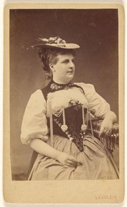 [Femme non identifiée en costume indigène avec chapeau, assise].