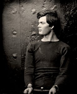 Lewis Powell avec des fers aux poignets à bord de l