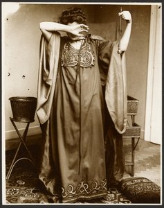 [Modèle féminin debout, une main sur le visage, tenant une orbe dans l