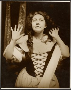 [Modèle féminin en costume de paysanne posant en regardant vers le haut]