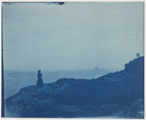 Femme regardant une goélette depuis un promontoire rocheux - American Photographer
