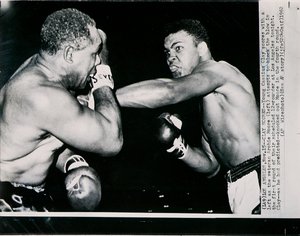 Le Jeune Cassius Clay marque un point avec un gauche contre le vétéran Archie Moore au premier round du combat à Los Angeles - American Photographer