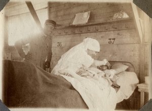 Première Guerre mondiale 1914-1918 : infirmière en blouse rasant un soldat (blessé de guerre français allongé dans un lit), à Couville, Manche, Basse-Normandie, France. Photographie anonyme juillet 1917. Collection privée, Stella. - Anonymous Anonymous
