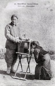 Petit métier : un amuseur ambulant avec une boîte à images Photographie du début du 20ème siècle - Collection privée - Anonymous Anonymous