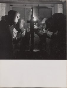 [Quatre hommes portant des casques de soudure soudent une pièce de métal].