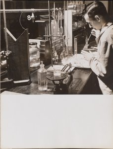 [Un homme dans un laboratoire utilise ses deux mains pour placer une grande pipette dans un bécher]. - Arnold Eagle
