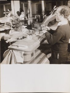 [Un homme utilise une machine pour presser des robes].