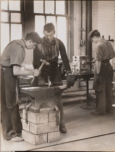 [Deux hommes martèlent du métal sur une enclume].