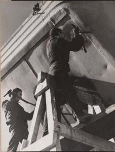 [Deux hommes travaillent sur le dessous d