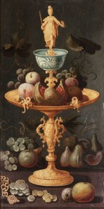 Raisins, prunes et une grenade sur une tazza dorée surmontée d