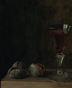 Un verre de vin avec des noix sur une table