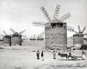 Moulins à vent sur la mer Méditerranée à Alexandrie, Égypte. Devant, des Égyptiens posant avec une petite charrette