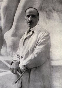 Portrait en trois-quarts du sculpteur Edoardo Rubino avec un marteau à la main. En arrière-plan, une sculpture peut être distinguée