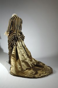 Robe de soirée, vers 1884 (vue oblique arrière). Satin de soie et velours coupé, dentelle, glands et franges en fil de soie. Charles Frederick Worth, France. - Charles Frederick Worth