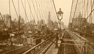 Lower Manhattan vu à travers le réseau de câbles sur le pont suspendu de Brooklyn, vers 1930