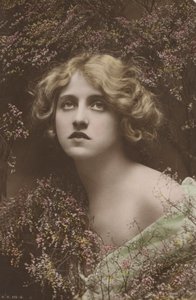 Belle fille, entourée de ce qui semble être de la bruyère (photo)