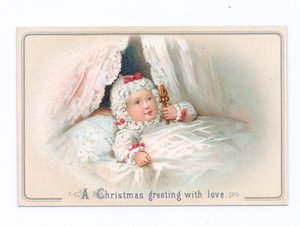 Carte de Noël victorienne avec un enfant au lit tenant un hochet, vers 1880 (lithographie en couleur)