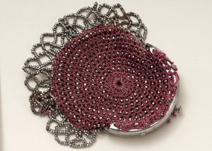 Sac rose avec fermoir supérieur, décoration de perles et bordure en maille