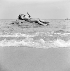 Fille prenant un bain de soleil sur un rocher à Cefalu - Fosco Maraini