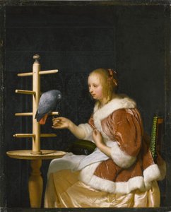 Jeune femme nourrissant un perroquet