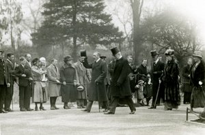 Le roi George V, levant son chapeau à la foule devant son entourage, lors d